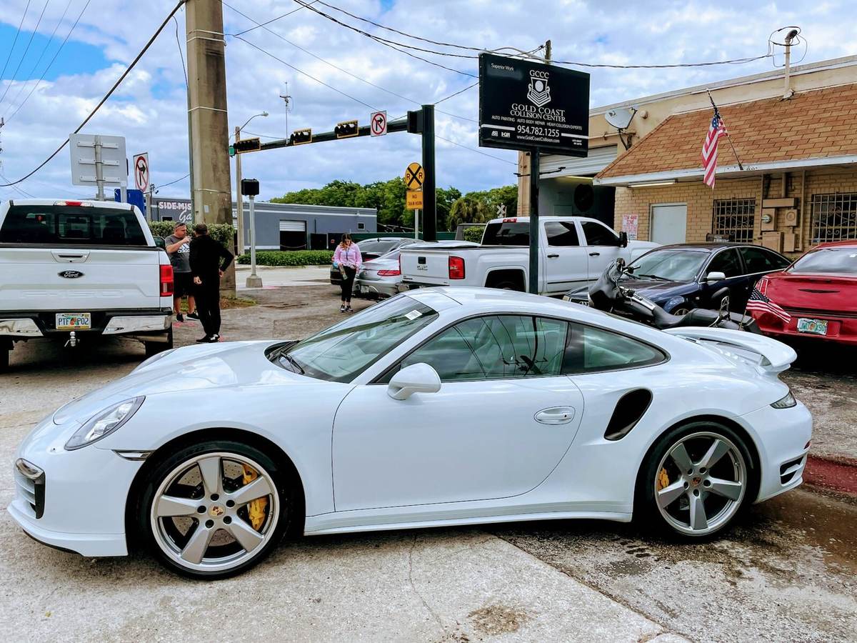White Porsche 911 Turbo S outside Gold Coast Collision Center in Pompano Beach after body repair